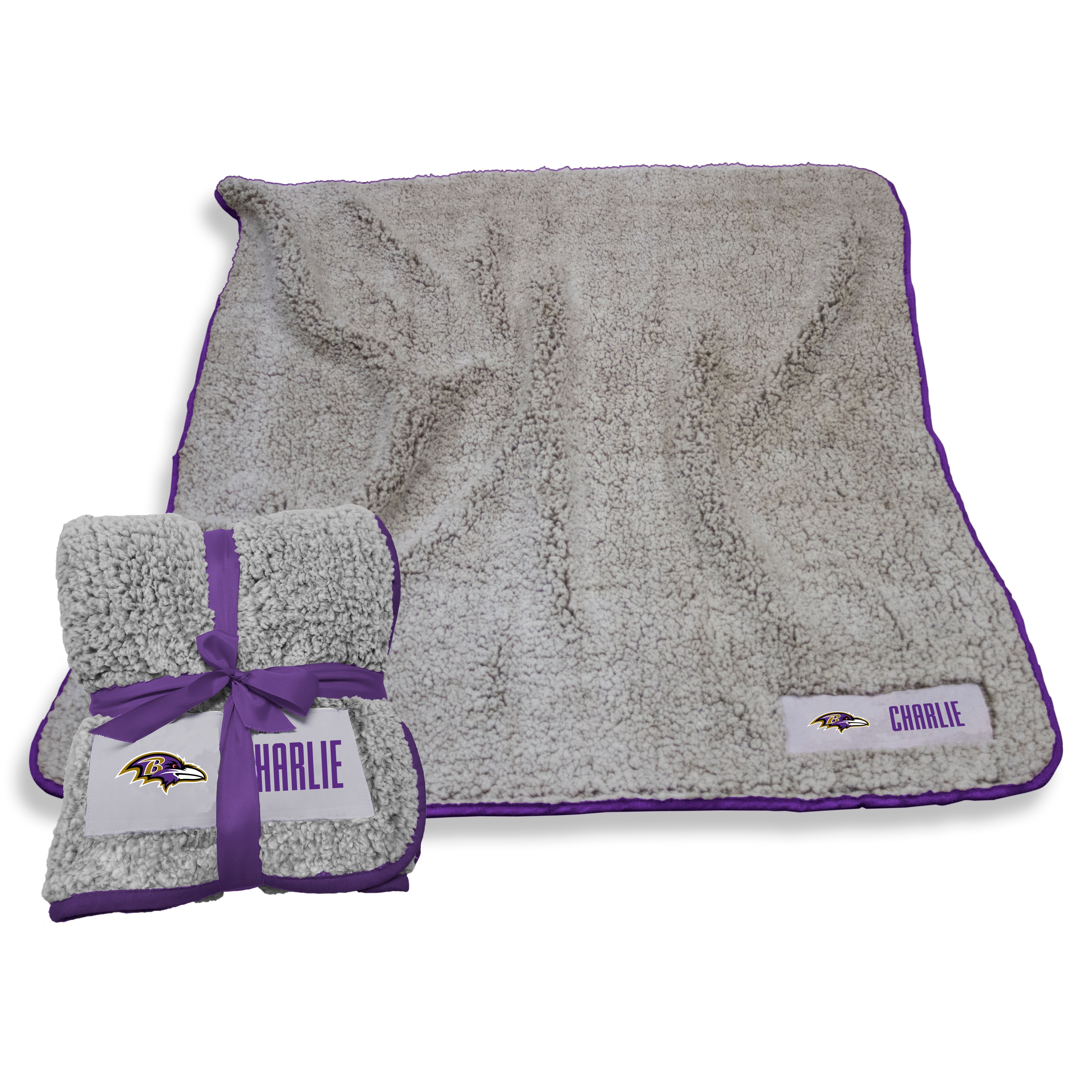 Baltimore Ravens Frosty Fleece Throw blanket, crafted from luxurious high-pile sherpa material, perfect for tailgating, home relaxation, or travel. Features team logo twill patch, lightweight design, and machine washable for easy care. Ideal gift for sports fans, measuring 50x60 inches with a lifetime guarantee.